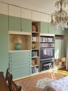 a room with a book shelf and a tv at La Romantique in Paris