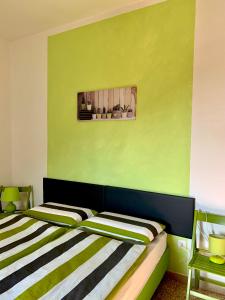 1 dormitorio con 2 camas y pared verde en Casa al Capitello en Malcesine