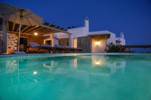 a swimming pool in front of a villa at night at ΑΙΩΡΑ in Mýkonos City