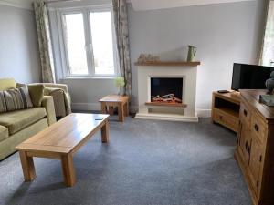 a living room with a couch and a fireplace at Postmans Rest, second floor apartment, Lynmouth with private parking in Lynmouth
