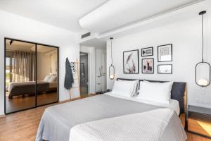 a white bedroom with a large bed and a mirror at Nouvelle Villa in Ierapetra +39 photos
