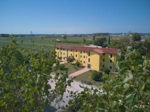 a large yellow building in a field with trees at Agriturismo ai Casali in Palazzolo dello Stella