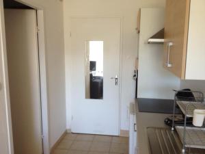 - une cuisine avec une porte blanche et un miroir dans l'établissement Appartement vue mer et montagne, à Calvi
