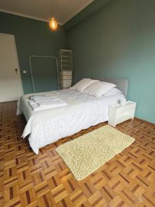 um quarto com uma cama e piso em madeira em Blue Bay Apartment Free bicycles em Setúbal