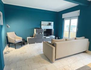 a living room with a couch and a tv at Blue Bay Apartment in Setúbal