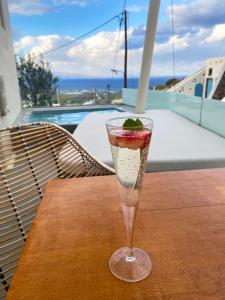 a glass with a strawberry in it sitting on a table at Edem Boutique Suites in Oia