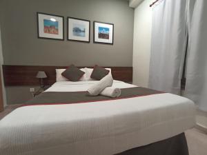 1 dormitorio con 1 cama blanca grande y 2 almohadas en CH Murallas II, en Madrid
