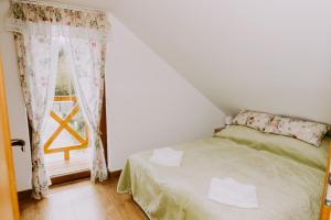 niewielka sypialnia z łóżkiem i oknem w obiekcie Słoneczna Chałupka w Zawoi