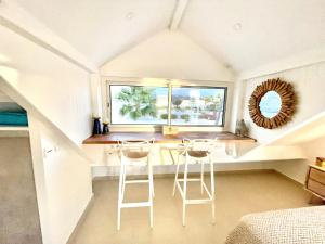 Habitación con 2 taburetes y ventana en Blue Dream 3 à 5 chambres villa sur la plage, en Baie Nettle