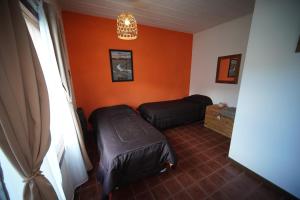 a room with orange walls and a bed and a window at Magna in El Chalten