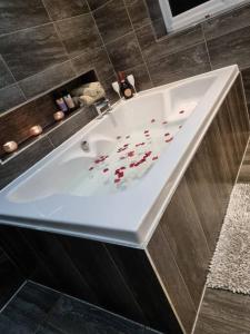 a white bath tub with hearts on it in a bathroom at 4 Bedroom Detached Holiday home with Hot Tub in Wrexham
