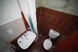 Un baño con lavabo, inodoro y ducha. en Magna, en El Chaltén