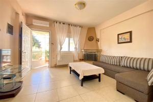 a living room with a couch and a table at Elpida House on the Beach (2 bedrooms 6 guests) in Kalivia Poligirou