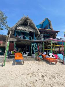 een gebouw op het strand met stoelen en mensen bij Cabaña Luna Azul in Playa Blanca