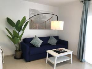 a living room with a blue couch and a table at Apartamento Olivin in Puerto del Carmen