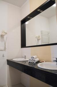 a bathroom with two sinks and a large mirror at Vęgoria 17 Apartament przy porcie in Węgorzewo