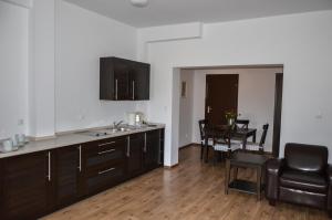 a kitchen with a sink and a table with a chair at Vęgoria 17 Apartament przy porcie in Węgorzewo