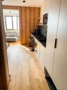 eine Küche mit weißen Schränken und Holzböden in der Unterkunft Palace 404 in Špindlerův Mlýn