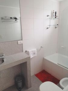 a bathroom with a toilet and a tub and a sink at Palermo Deluxe Apartment in Buenos Aires