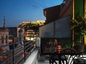 eine Terrasse mit Tisch und Stühlen auf einem Balkon in der Unterkunft Athens City View Urban Suites in Athen