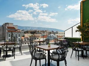 un patio con mesas y sillas en el balcón en Athens City View Urban Suites, en Atenas
