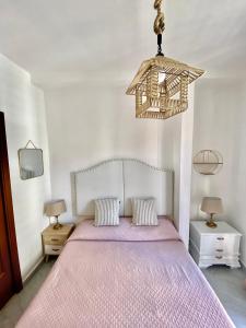 a bedroom with a bed with a pink bedspread at La Casetta In Centro - Holiday House in Scilla