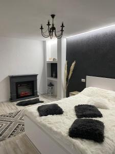- une chambre avec un lit blanc et une cheminée dans l'établissement Apartament Maria, à Alba Iulia