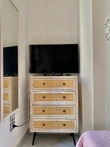 a bedroom with a dresser with a flat screen tv at La Casetta In Centro - Holiday House in Scilla