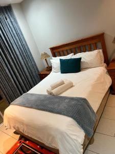 a bedroom with a large white bed with a blue pillow at 201 St Tropez, South Coast in Margate
