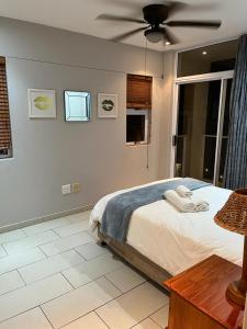 馬蓋特的住宿－201 St Tropez, South Coast，一间卧室配有一张床和吊扇