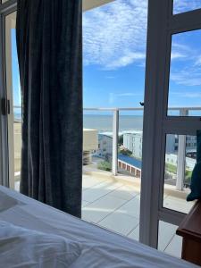 a bedroom with a bed and a view of the ocean at 201 St Tropez, South Coast in Margate