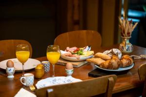 a wooden table with food and glasses of orange juice at B&B In den Wijde Koe in Maassluis