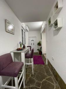 a living room with a table and purple chairs at JOCKER in Virpazar