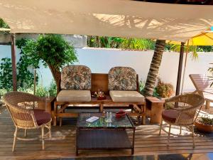 布希奧斯的住宿－Loft a 600 metros da praia c piscina em Buzios RJ，庭院配有桌椅和遮阳伞。