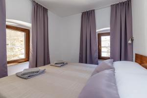 a bedroom with a large bed with purple curtains at House Aves 2 in Kaštelir