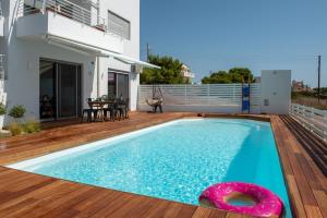 una piscina en una terraza con una casa en Evaeri villa, en Artemida