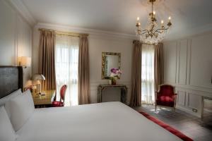 um quarto com uma cama grande e um lustre em Alvear Palace Hotel - Leading Hotels of the World em Buenos Aires