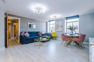 Stunning Apartment - 10 Minutes From Leeds في ليدز: غرفة معيشة مع أريكة زرقاء وطاولة