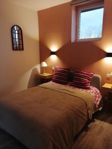 a bedroom with a bed with two pillows and a window at lou pitchou prats in Audon