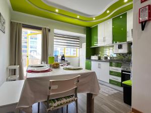 a kitchen with green walls and a table with chairs at Praia da Rocha, Flamingo, Wi-Fi gratuito by S&BP in Portimão