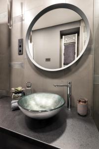 a bathroom with a bowl sink and a mirror at Holló 3 Bedroom Downtown Apartment in Budapest