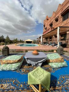 un patio con mesa y sillas frente a un edificio en villa darga rouge, en Marrakech
