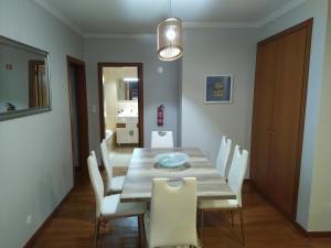 una sala da pranzo con tavolo in legno e sedie bianche di Sol & Mar Rancho a Câmara de Lobos