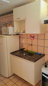 eine Küche mit einer Spüle und einem Kühlschrank in der Unterkunft Flat Di Roma Resort Internacional in Caldas Novas