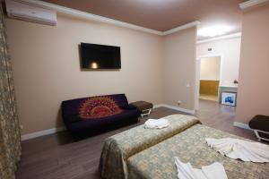ein Hotelzimmer mit 2 Betten und einem Sofa in der Unterkunft AVANTUL SCM in Drăgăşani