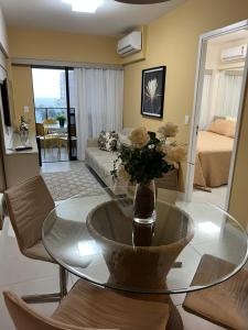 a living room with a glass table and a couch at Apto Top Custo-Benefício Qualidade e preço que surpreendem in Maceió