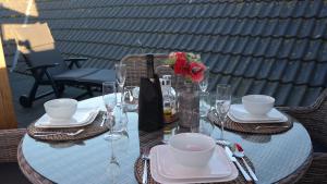 a table with plates and glasses and a vase with flowers at THE ROOFTOP - a trendy new apartment with airconditioning, large terrace & free parking in Ostend