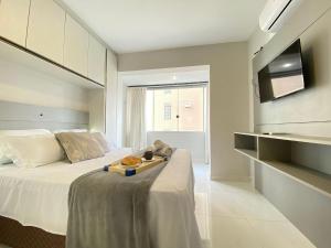 - une chambre avec un lit et un plateau de nourriture dans l'établissement LAS165 - Av. Central, Climatizado, Conforto, Wi-Fi, à Balneário Camboriú