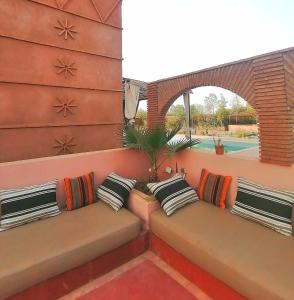una fila de almohadas sentadas en un banco en un patio en villa darga rouge en Marrakech