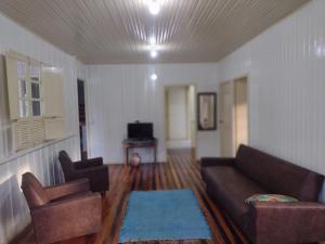 een woonkamer met een bank en twee stoelen bij Refúgio Villa Gervazi na Serra Rio do Rastro in Lauro Müller